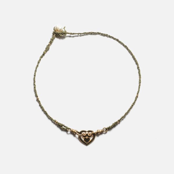 Collier monté sur un cordon Mokuba de couleur kaki avec en son centre un coeur en plaqué Or 18 carats entouré de fermoirs recyclés en bronze