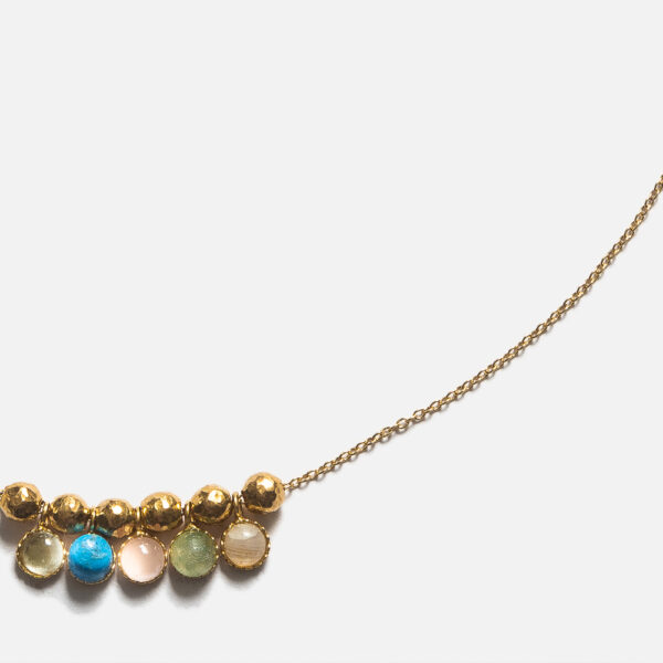 Collier monté sur une chaîne ajustable en Gold filled, il est composé de cabochons dentelés avec une Aigue-marine, un Quartz rose, une Turquoise, une Topaze bleue et une Pierre de lune